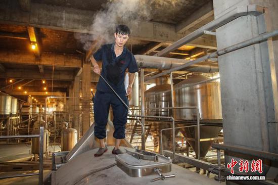 图为工人在茅台循环经济产业示范园生产。　中新网记者 瞿宏伦 摄