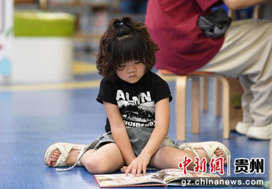 8月5日，在贵阳市南明区图书馆内儿童阅读区，一名小读者正品读儿童图书。