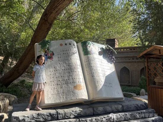 《葡萄沟》课文雕塑前，游客正在拍照留念。吐鲁番市融媒体中心记者 买迪努尔 摄7