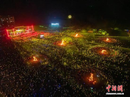 图为8月6日，民众在贵州省毕节市百里杜鹃管理区参加火把节活动。李华 摄