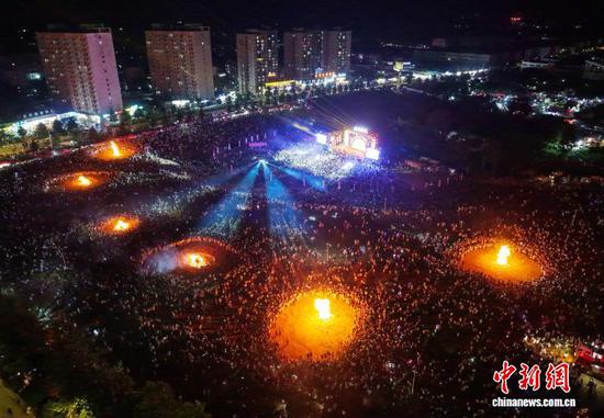 图为8月6日晚，航拍威宁自治县2026年避暑旅游季火把狂欢系列活动现场。(无人机图片)何欢 摄