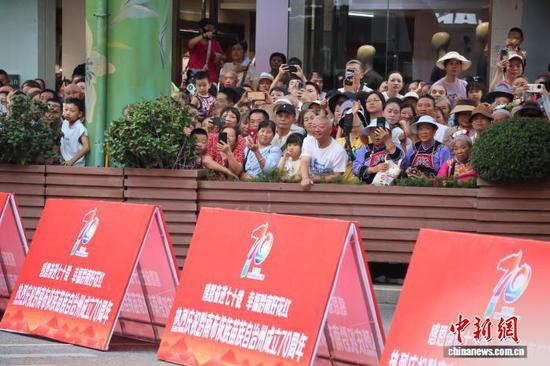 图为8月8日，黔南布依族苗族自治州成立70周年庆祝活动——民族团结大巡游现场，路边观众人头攒动，热闹非凡。中新网记者 刘美伶 摄