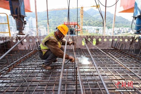 8月12日，工人在黄百铁路望谟河特大桥施工。中新社记者 瞿宏伦 摄