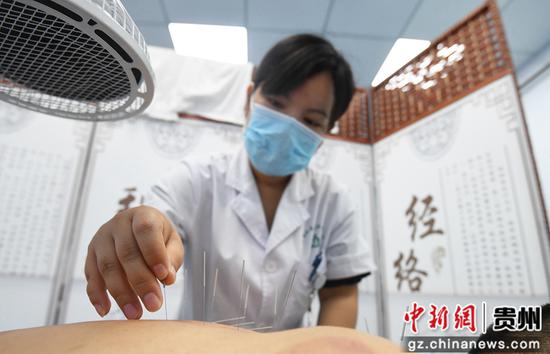 8月12日，贵阳市南明区西湖社区卫生服务中心的中西医结合临床医生正通过针灸疗法为患者治病。