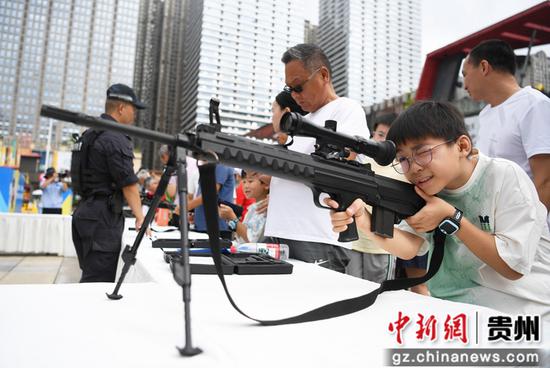 8月14日，在贵阳市公安局南明分局举行的“警营开放日”活动现场，一名小朋友正近距离体验警务装备。