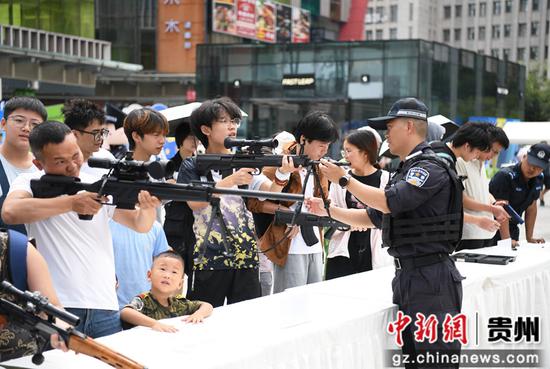 8月14日，在贵阳市公安局南明分局举行的“警营开放日”活动现场，市民在公安民警的指导下近距离体验警务装备。