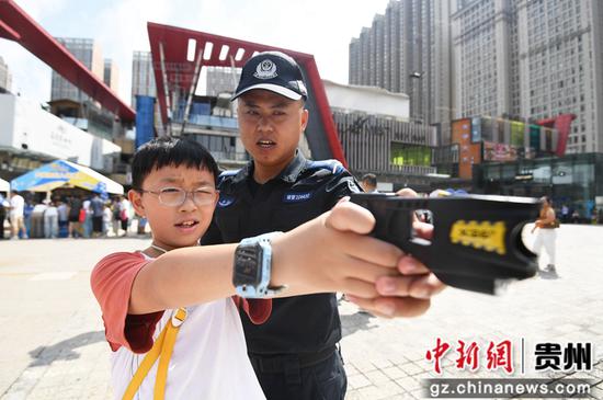 8月14日，在贵阳市公安局南明分局举行的“警营开放日”活动现场，一名小朋友在公安民警的指导下近距离体验警务装备。