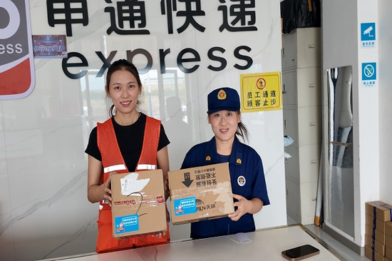 宣传人员与申通快递人员粘贴消防提示粘贴。