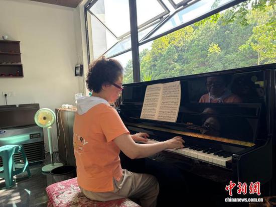 图为旅居在贵阳市乌当区羊昌村的游客在弹钢琴。记者 周燕玲 摄