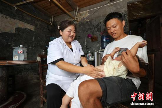 图为陈远秋上门随诊时给胀气孩童揉腹。中新社记者 瞿宏伦 摄 图为陈远秋上门随诊时给胀气孩童揉腹。中新社记者 瞿宏伦 摄