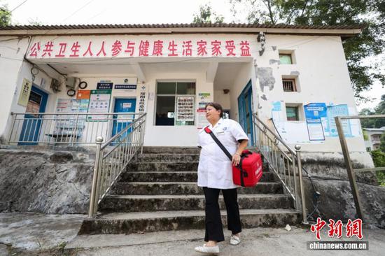 图为陈远秋走出卫生室准备去村民家中上门随诊。中新社记者 瞿宏伦 摄 图为陈远秋走出卫生室准备去村民家中上门随诊。中新社记者 瞿宏伦 摄