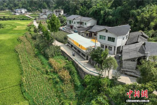 图为陈远秋骑车出诊,为了让更多行动不便的村民在家就能享受到诊疗服务,陈远秋特意学习了摩托车驾驶技术,路远的地方就用摩托车代步。(无人机照片)中新社记者 瞿宏伦 摄 图为陈远秋骑车出诊,为了让更多行动不便的村民在家就能享受到诊疗服务,陈远秋特意学习了摩托车驾驶技术,路远的地方就用摩托车代步。(无人机照片)中新社记者 瞿宏伦 摄