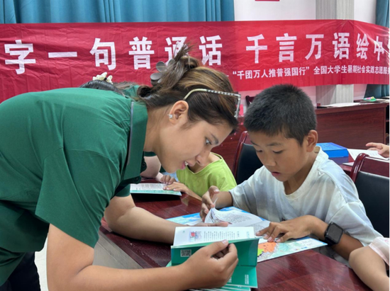 实践团成员带领孩子们共读推普手册、解读法律条例。