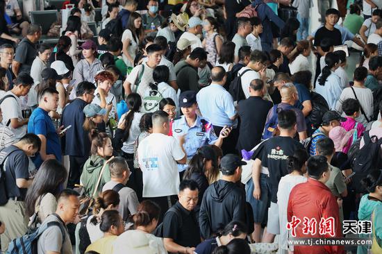 图为北京铁路公安局天津公安处民警在旅客中维护上车秩序。(北京铁路公安局天津公安处供图) 图为北京铁路公安局天津公安处民警在旅客中维护上车秩序。(北京铁路公安局天津公安处供图)