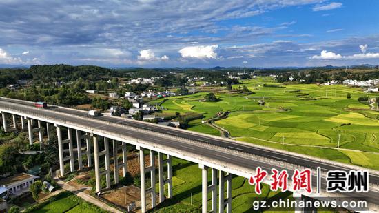 贵州黔西金碧镇铧口寨社区蓝天白云高架桥与村庄稻田浑然一体。  张宇摄