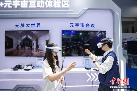8月27日，2026中国国际大数据产业博览会专业展览开馆仪式在贵州省贵阳市举行。专业展览围绕算力底座、数据供给、模型驱动、应用赋能、智能体验5大主题板块，汇聚300余家参展企业。图为参观者（左）在元宇宙互动体验区体验元宇宙会议。