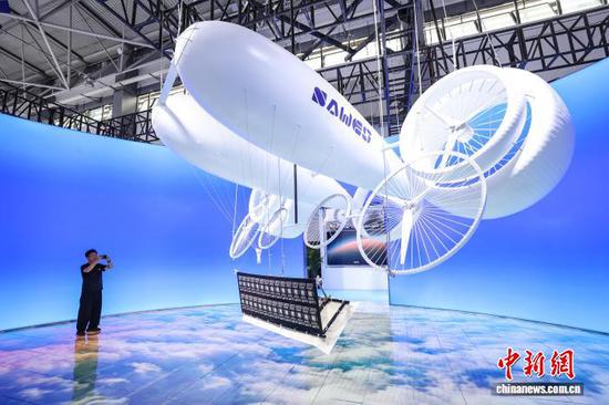 8月28日，参观者在拍摄临一云川展区的“平流层浮空风力发电系统”。中新社记者 瞿宏伦 摄