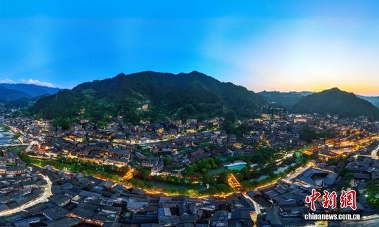 夜幕降临，苗家人陆续点亮自家吊脚楼上的灯火，从观景台俯瞰整个苗寨星光点点，流光溢彩，山、楼、桥、水交相辉映。图/CNSphoto 何华文 摄