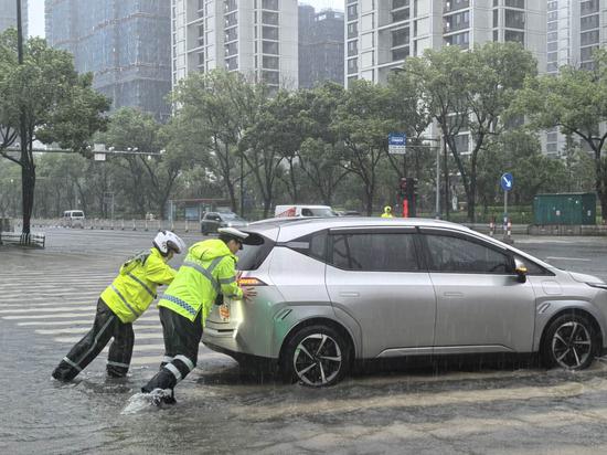 交警合力将抛锚车辆推至安全路段