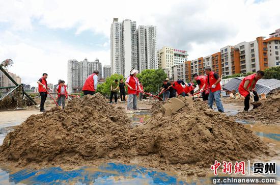 5月20日，都匀市干部群众在水上体育中心清理泥沙。
