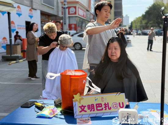 9月4日，乌鲁木齐市友好北路太百购物商场门前的一场“文明巴扎”公益集市现场，“益剪美联盟”志愿服务队为居民免费理发。石榴云/新疆日报记者 孙芳婷摄mage