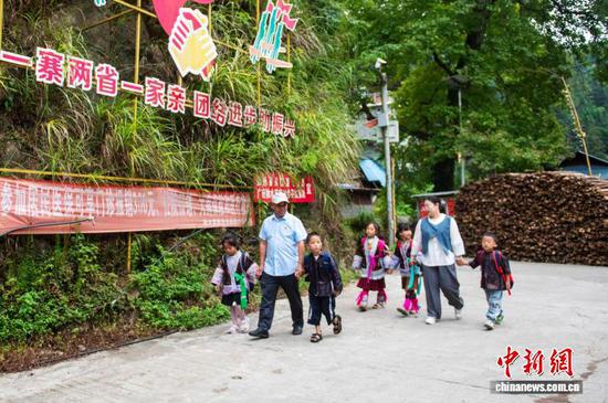 图为潘先锋与彭韩萍在护送学生放学回家途中。吴德军 摄 图为潘先锋与彭韩萍在护送学生放学回家途中。吴德军 摄