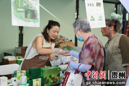 图为游客在贵州展区试吃梵净抹茶产品。