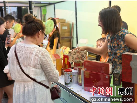 图为游客在贵州展区购买商品。