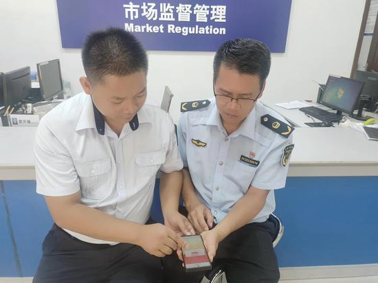 图为宜州烟草、市监工作人员现场交流线上答题知识点。韦东 摄 图为宜州烟草、市监工作人员现场交流线上答题知识点。韦东 摄