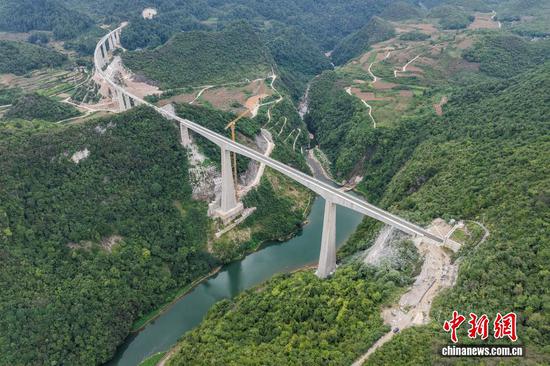 9月7日，贵州省瓮安县，航拍建设中的瓮马铁路瓮安河大桥，该大桥全长395米。贵州瓮安至马场坪铁路（瓮马铁路）南北延伸线项目，作为贵州省重要的资源开发型铁路，共有桥梁114座，隧道56座，桥隧比为69%。其中，乌江特大桥、湘江特大桥等大桥作为全线控制性工程，修建难度大、技术要求高，建设者们克服困难，创新运用多项施工工艺，在崇山峻岭间架起了坚固通途。（无人机照片）