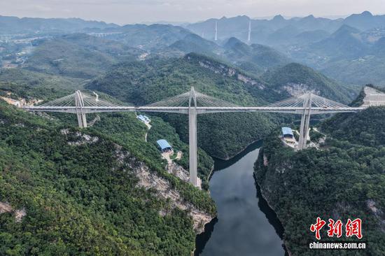 9月7日，贵州省播州区，航拍建设中的瓮马铁路湘江特大桥，该大桥全长723米。贵州瓮安至马场坪铁路（瓮马铁路）南北延伸线项目，作为贵州省重要的资源开发型铁路，共有桥梁114座，隧道56座，桥隧比为69%。其中，乌江特大桥、湘江特大桥等大桥作为全线控制性工程，修建难度大、技术要求高，建设者们克服困难，创新运用多项施工工艺，在崇山峻岭间架起了坚固通途。（无人机照片）