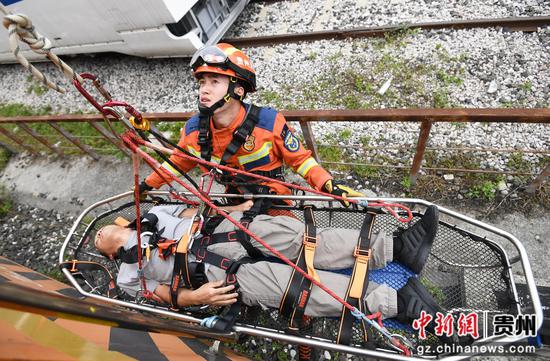 9月8日，贵阳市南明区消防救援人员正在模拟轨道事故实景救援演练现场利用救援担架转移被困人员。