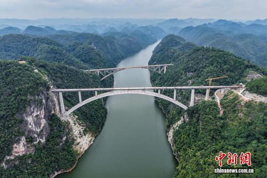 9月7日，贵州省瓮安县，航拍建设中的瓮马铁路乌江特大桥（前），该大桥全长520米。贵州瓮安至马场坪铁路（瓮马铁路）南北延伸线项目，作为贵州省重要的资源开发型铁路，共有桥梁114座，隧道56座，桥隧比为69%。其中，乌江特大桥、湘江特大桥等大桥作为全线控制性工程，修建难度大、技术要求高，建设者们克服困难，创新运用多项施工工艺，在崇山峻岭间架起了坚固通途。（无人机照片）