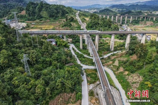9月7日，贵州省麻江县，航拍建设中的瓮马铁路下穿沪昆高铁大桥。贵州瓮安至马场坪铁路（瓮马铁路）南北延伸线项目，作为贵州省重要的资源开发型铁路，共有桥梁114座，隧道56座，桥隧比为69%。其中，乌江特大桥、湘江特大桥等大桥作为全线控制性工程，修建难度大、技术要求高，建设者们克服困难，创新运用多项施工工艺，在崇山峻岭间架起了坚固通途。（无人机照片）