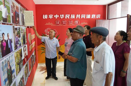 吴显明给群众讲解二堡镇的民族团结故事。（资料图）
