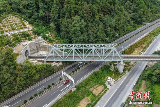 9月7日，贵州省麻江县，航拍建设中的瓮马铁路上跨G75兰海高速公路中桥。贵州瓮安至马场坪铁路（瓮马铁路）南北延伸线项目，作为贵州省重要的资源开发型铁路，共有桥梁114座，隧道56座，桥隧比为69%。其中，乌江特大桥、湘江特大桥等大桥作为全线控制性工程，修建难度大、技术要求高，建设者们克服困难，创新运用多项施工工艺，在崇山峻岭间架起了坚固通途。（无人机照片）