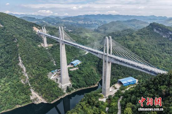 9月7日，贵州省播州区，航拍建设中的瓮马铁路湘江特大桥，该大桥全长723米。贵州瓮安至马场坪铁路（瓮马铁路）南北延伸线项目，作为贵州省重要的资源开发型铁路，共有桥梁114座，隧道56座，桥隧比为69%。其中，乌江特大桥、湘江特大桥等大桥作为全线控制性工程，修建难度大、技术要求高，建设者们克服困难，创新运用多项施工工艺，在崇山峻岭间架起了坚固通途。（无人机照片）