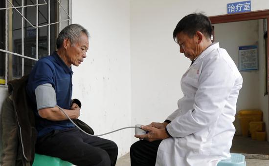 村医蒋才明给村民测量血压 周海东 摄