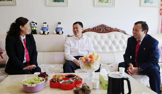 在教师董席静家中，县委书记朱宏伟与其亲切交谈。
