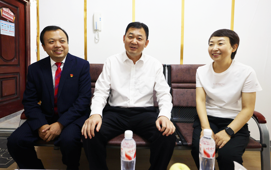 在教师马文珍家中，县委书记朱宏伟与其亲切交谈。