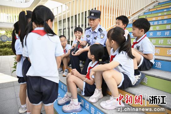 图为:民警在开学期间和学生互动。中新社发 王怡蔷 供图 图为:民警在开学期间和学生互动。中新社发 王怡蔷 供图