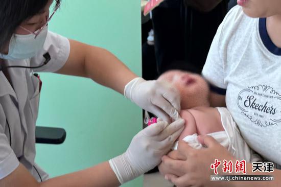 图为冯女士带着宝宝接种三组分百白破疫苗。（受访单位供图）