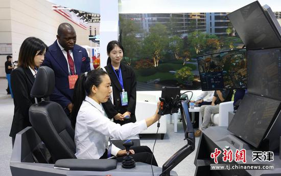 图为中外嘉宾在博览会现场体验5G智能塔吊系统。（中建六局供图）