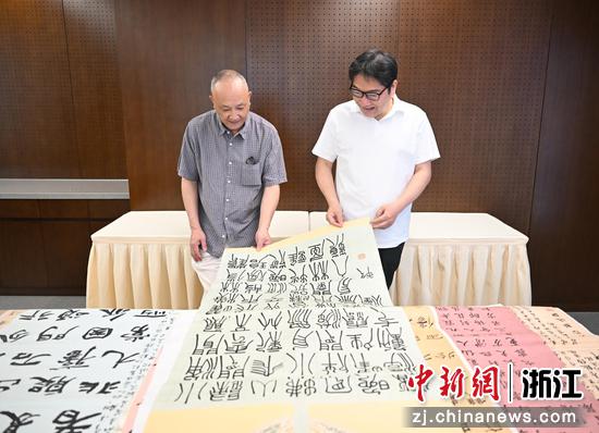 图为：中国书法家协会隶书委员会委员，浙江省书法家协会副主席、隶书委员会主任，浙江书法院副院长何来胜（左），以及中国书法家协会理事、浙江省书法家协会副主席兼秘书长、西泠印社社员何涤非（右）进行评审。中新社记者 王刚 摄