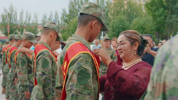 　　在精河县新兵欢送活动现场，家属为新兵佩戴红花。来源：精河零距离