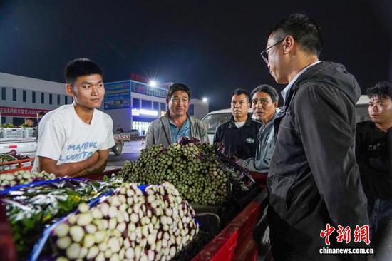 图为9月21日，威宁自治县江楠物流园，菜农在和收购商议价。赵庆能 摄