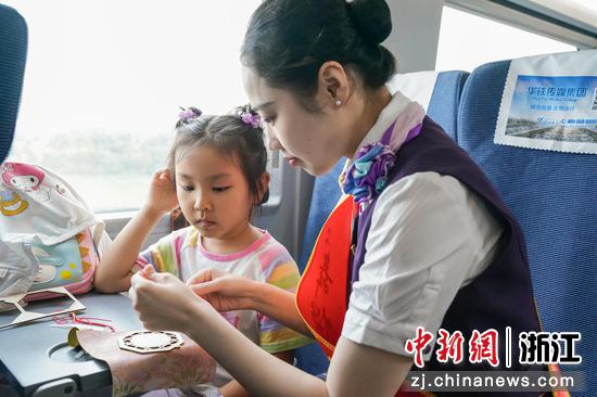 图为：乘务员和乘客进行中秋手工创作。中新社发 高艳 供图
