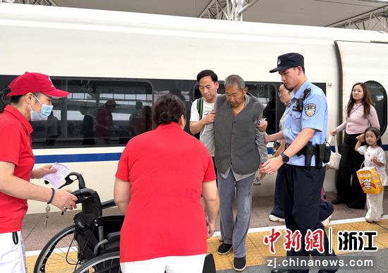 图为：铁路民警帮助旅客。中新社发 贺瑞明 供图