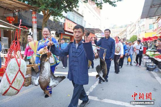 图为庆丰收巡游活动现场，村民带着农特产品参加巡游，展示丰收成果。杨菊梅 摄