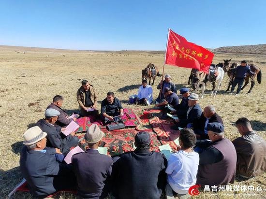 别个依（中间）在向牧民宣讲。记者岳文玲 摄